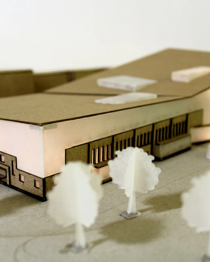 Detalle de maqueta cortada a láser con cantos tostados y árboles de acrílico translúcido sobre la base